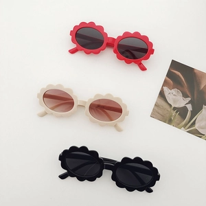 Three pairs of kids cute flower shaped oval sunglasses in red, beige and black colors