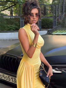 Detail of yellow sleeveless high-neck dress showing elegant waist ruching and drape