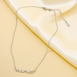 Macro detail of silver mami pendant and S.STEEL hallmark on polished heart necklace