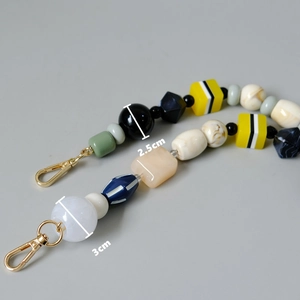 Macro detail of multi-color retro handmade beads with size markers and gold spring clasps