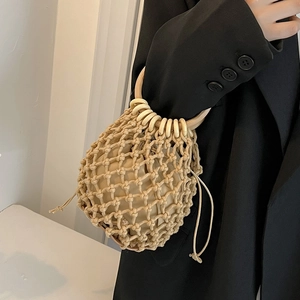 Detail of handmade straw bucket bag with wooden ring handle and inner drawstring pouch