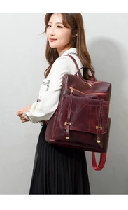 Vista lateral de mujer con mochila de cuero PU burdeos y detalles de cremallera dorada