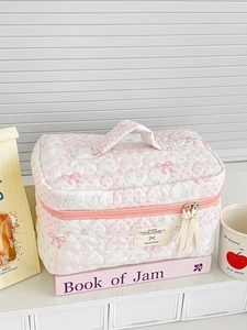 Pink and white quilted floral makeup bag with sweet bow print and top handle for travel