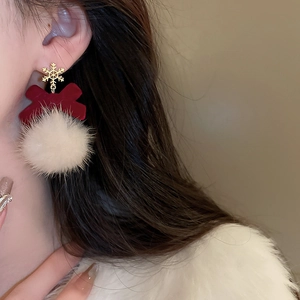 Detail of snowflake stud and velvet bow with white fluffy ball on Christmas earring