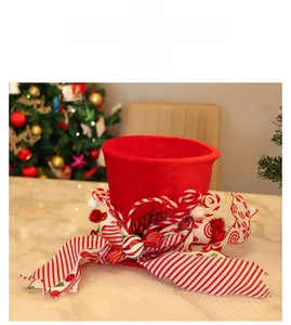 Detail of a red velvet Christmas tree topper hat with festive candy canes and ribbons