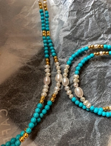Detail of 18K gold-plated necklace with fresh water pearls and turquoise beads