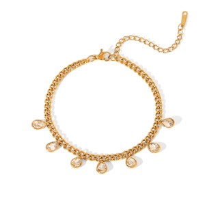 Macro detail of golden Cuban chain bracelet with sparkling teardrop zircon charms