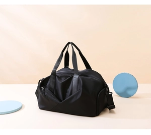 Detail view of the black waterproof nylon travel bag with adjustable shoulder straps