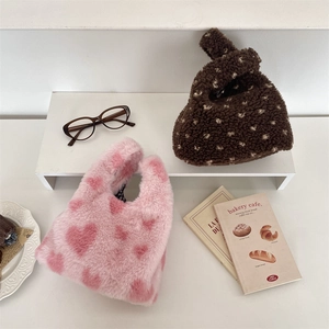 Détail de sacs à main en peluche à motif cœur rose et marron avec fausse fourrure