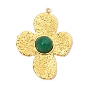 Close-up of golden floral pendant with central green cabochon gemstone and petal texture