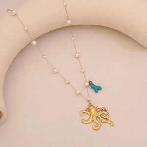Detail of gold octopus pendant with turquoise coral and pearls on a dainty chain