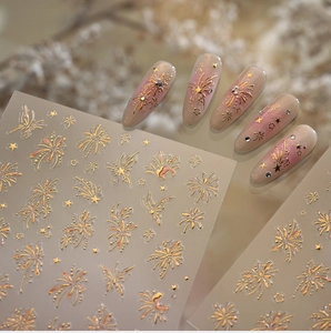 Macro detail of gold embossed firework and butterfly nail stickers on gradient nails