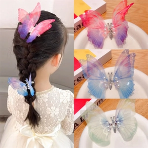 Macro detail of gauze butterfly clips with pearls and colorful gradient wing textures