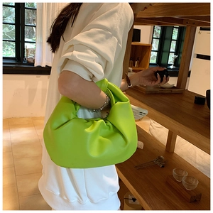 Detail view of the lime green ruched cloud bag featuring a unique knotted handle design