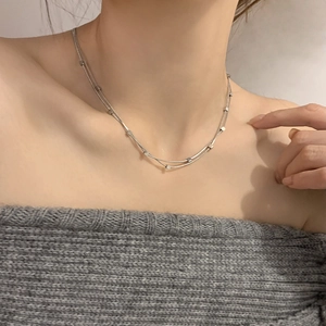 Detail of silver double-layered titanium steel necklace with small square pendants