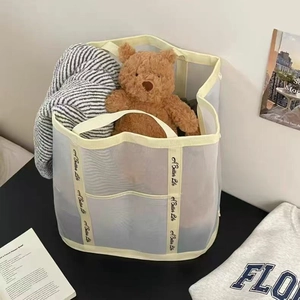 Cream mesh laundry basket with handles and 'A Better Life' straps for home organization
