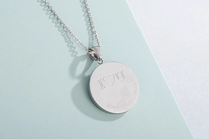 Detailed shot of polished silver round pendant necklace with I Love You engraving