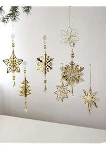 Golden Christmas tree ornaments with snowflakes, bells and beads hanging on a branch