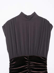 Détails de plis en mousseline grise et velours marron sur une robe courte
