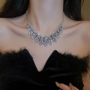 Close-up of geometric tassel necklace with pink and black crystals on model's neck