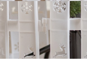 Close-up of interlocking buckle on white plastic Christmas fence with snowflake carvings