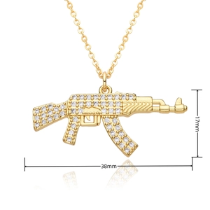 Macro detail of gold AK-47 pendant with zircons showing dimensions 17mm by 38mm