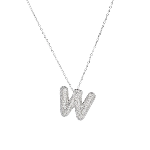 Macro shot of a silver letter W pendant with micro-pave cubic zirconia on a white background