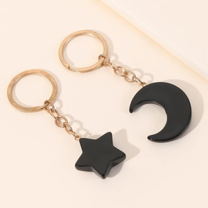 Matching star and moon keychain set in black resin with gold metal ring for couples
