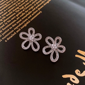 Vue détaillée des boucles d'oreilles fleurs évidées en argent avec pavé de zircons