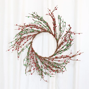 Minimalist Christmas wreath with red and green berries on a rustic brown branch base