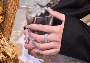 Close-up of luxury silver band ring with five rows of micro-pave crystals on female hand