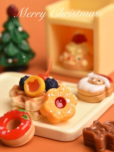 Vista macro di cibo in miniatura natalizio con mini waffle e omino di pan di zenzero