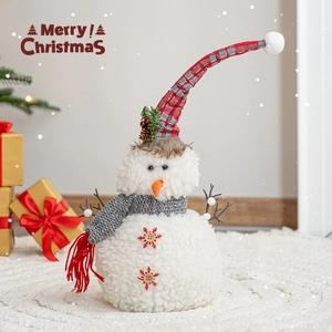 Christmas snowman plush ornament with red plaid hat on white rug for festive home decor