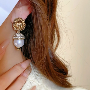 Vintage gold lion head pearl earrings with crystal inlay on a fashion model profile