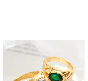 Close-up of vintage 18K gold plated rings with green emerald and white zircon stones