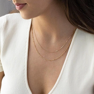 Close-up of double-layer gold plated stainless steel satellite chain necklace on a model