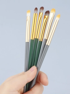 Close-up of makeup brushes with gold ferrule and dual-tone bristles for eye detail