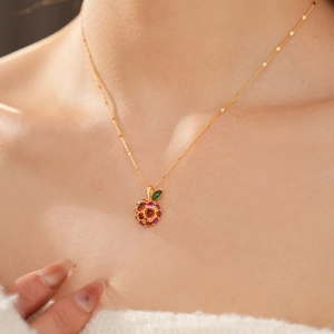 Detail of 14k gold plated apple pendant necklace with colorful zircons on female neck