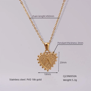 Macro detail of PVD 18k gold plated heart pendant with textured finish and embossed A letter