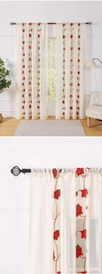 Detail of floral embroidery on sheer lace curtains with red flowers and green leaves