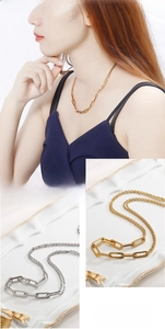 Detail of chunky gold and silver chain link necklace showing layered style and contrast