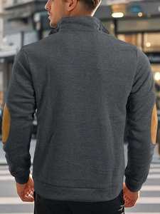 Back view of men's dark grey quarter-zip sweatshirt with brown elbow patches in street style