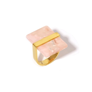 Detail view of bold gold stainless steel ring with pink marble resin rectangle inlay