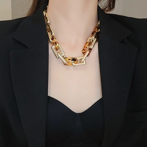 Dettaglio della collana a catena leopardata indossata con finiture in oro vintage