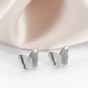 Silver butterfly earrings in polished and frosted stainless steel on pink silk