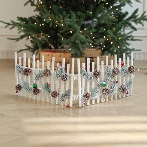White wooden Christmas fence with snow finish and pine cones for festive scene decor