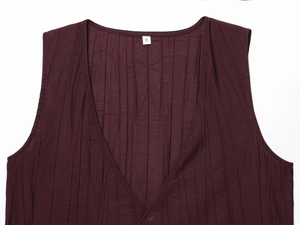 Close-up of wine red sleeveless top with fine vertical pleats and size label detail