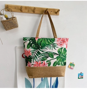 Detail of tropical monstera leaf print on canvas and jute tote hanging on a hook