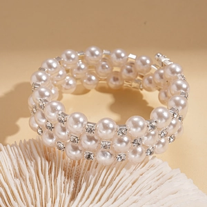 Macro detail of triple-layered pearl bracelet with sparkling rhinestone spacers