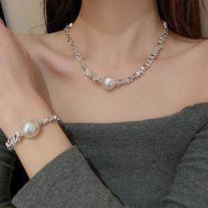 Close-up of irregular silver beads necklace and bracelet set with large white pearls